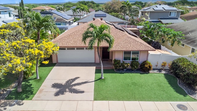 view of front of home featuring driveway, roof with shingles, an attached garage, fence, and a front lawn