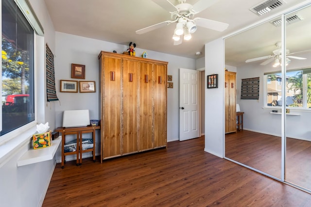 bedroom featuring a ceiling fan, visible vents, and wood finished floors