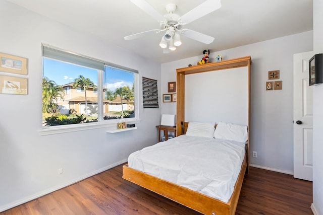 bedroom with ceiling fan, baseboards, and wood finished floors