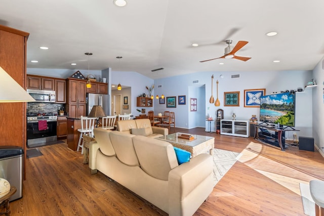 living area with visible vents, a ceiling fan, wood finished floors, vaulted ceiling, and recessed lighting