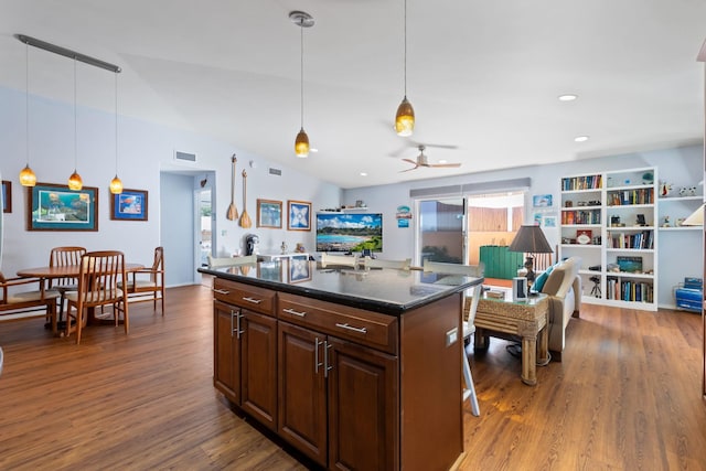 kitchen featuring a kitchen island, wood finished floors, visible vents, open floor plan, and hanging light fixtures