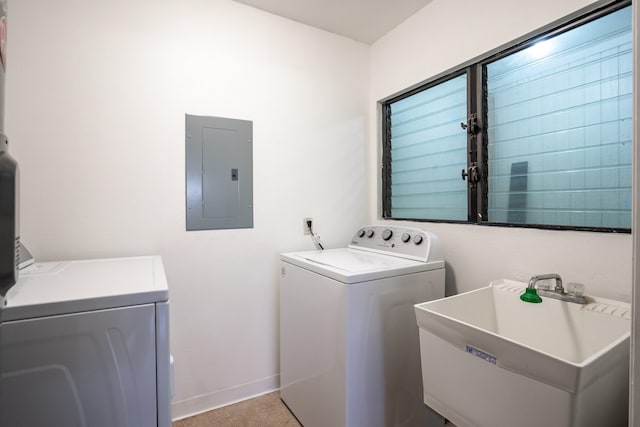 washroom with electric panel, washer and dryer, light carpet, and sink