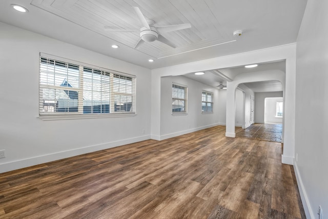 unfurnished living room with ceiling fan, dark hardwood / wood-style floors, a healthy amount of sunlight, and wood ceiling