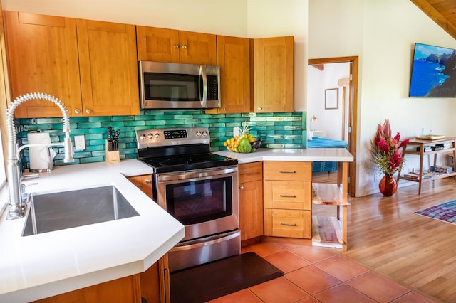 kitchen featuring vaulted ceiling, tasteful backsplash, stainless steel appliances, and light tile floors