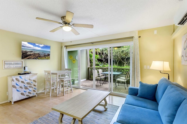 living area featuring light wood-style flooring, a ceiling fan, a textured ceiling, and a wall mounted AC