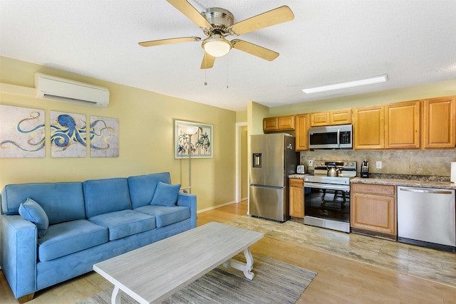 living room with light wood-style floors, an AC wall unit, ceiling fan, and baseboards