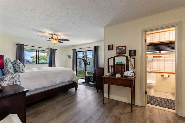 bedroom featuring ceiling fan, ensuite bath, access to outside, and dark hardwood / wood-style floors