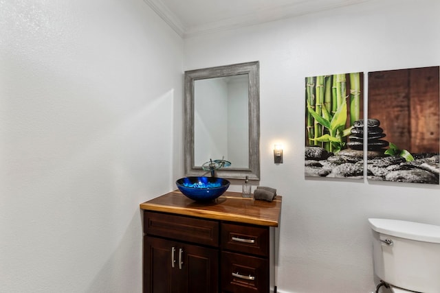 bathroom with vanity, toilet, and ornamental molding