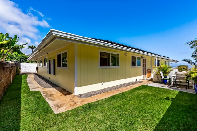 rear view of house with a yard and a patio