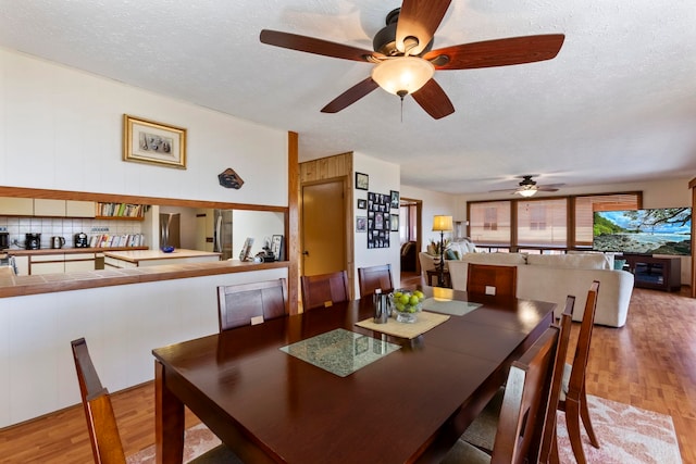 dining area featuring a textured ceiling, light hardwood / wood-style floors, and ceiling fan