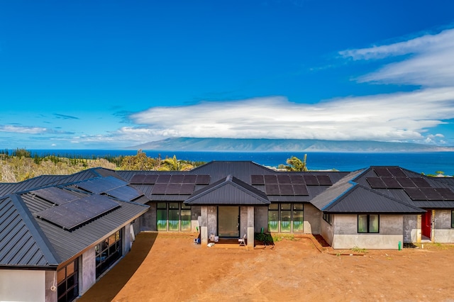 view of front of home featuring solar panels, a lanai, and a water and mountain view