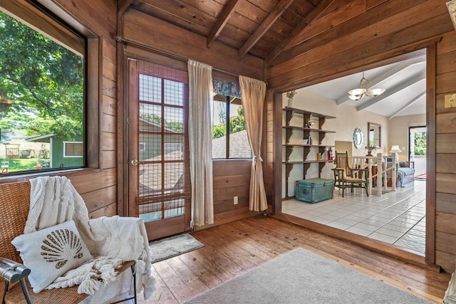 living area featuring wood ceiling, wooden walls, a notable chandelier, vaulted ceiling with beams, and wood-type flooring