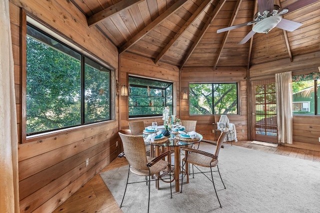 unfurnished sunroom featuring ceiling fan, vaulted ceiling with beams, and wooden ceiling