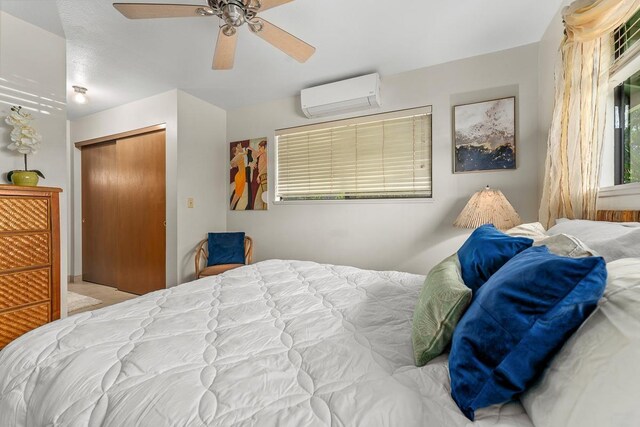 bedroom with ceiling fan, a closet, and a wall mounted air conditioner