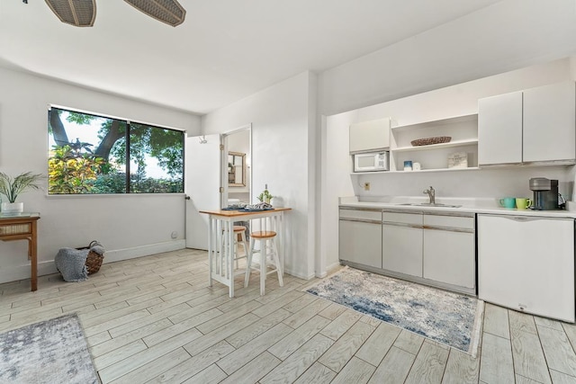 kitchen with white cabinetry, sink, and white appliances