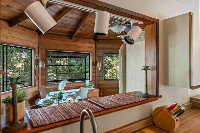 dining space featuring wooden ceiling, wood-type flooring, a wealth of natural light, and wooden walls