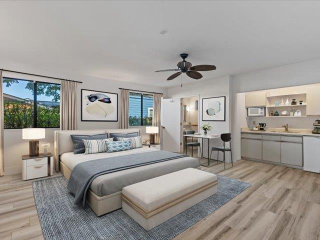 bedroom with ceiling fan, sink, multiple windows, and light hardwood / wood-style flooring