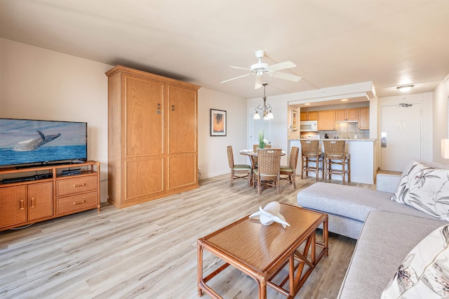 living room with ceiling fan and light hardwood / wood-style floors