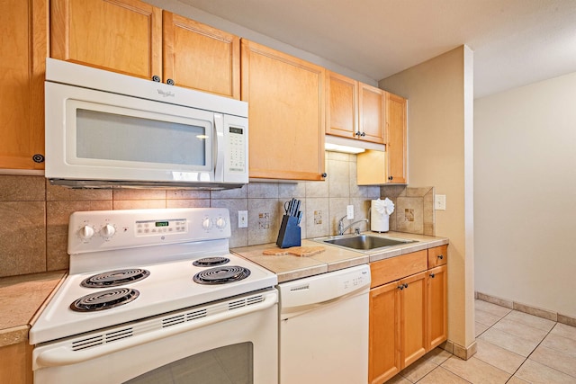 kitchen featuring white appliances, light brown cabinets, tasteful backsplash, sink, and light tile patterned floors