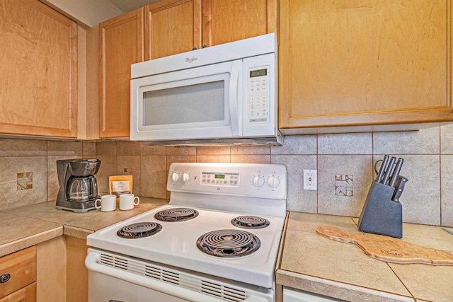 kitchen featuring backsplash and white appliances