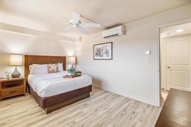 bedroom with light wood-type flooring, ceiling fan, and a wall mounted air conditioner