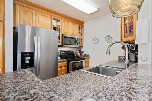 kitchen with sink, dark stone countertops, and appliances with stainless steel finishes