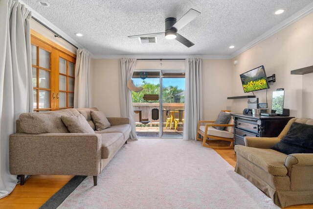 living room featuring crown molding, a textured ceiling, and ceiling fan