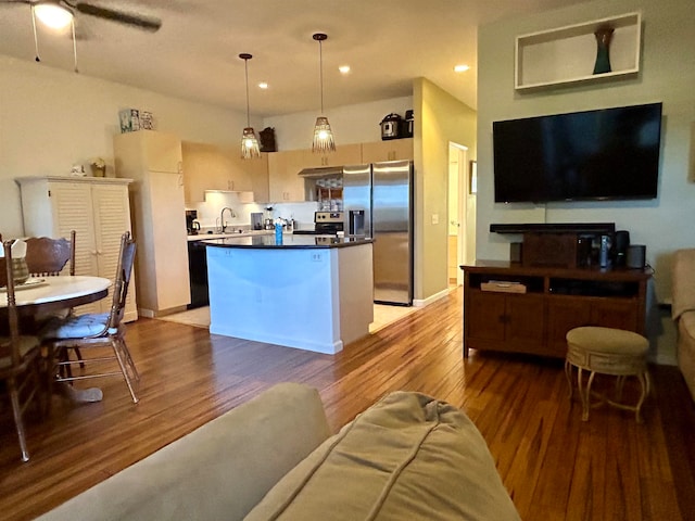 kitchen with pendant lighting, stainless steel appliances, light hardwood / wood-style floors, and a center island