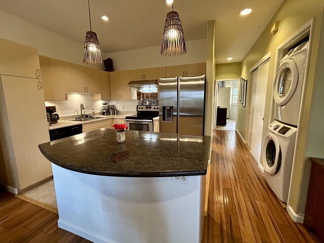 kitchen featuring light hardwood / wood-style floors, sink, appliances with stainless steel finishes, and stacked washer and dryer