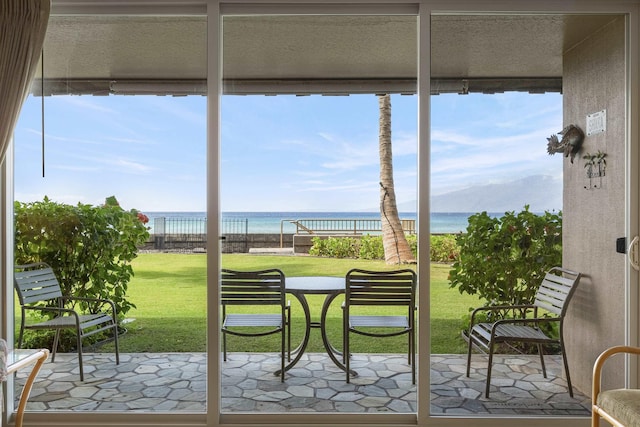 sunroom featuring a water view