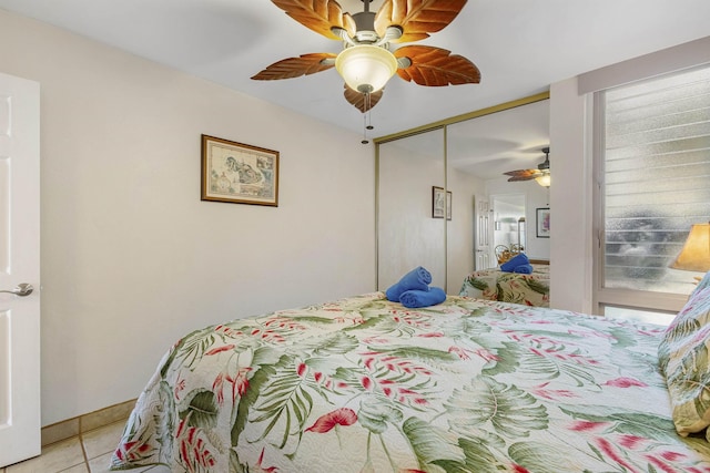 bedroom with light tile patterned floors, ceiling fan, multiple windows, and a closet