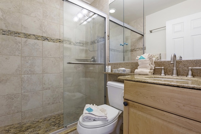 full bath with a stall shower, vanity, and toilet