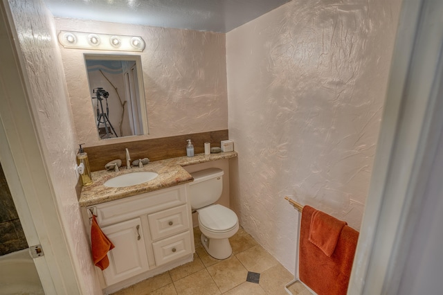 bathroom with tile patterned floors, walk in shower, toilet, and vanity