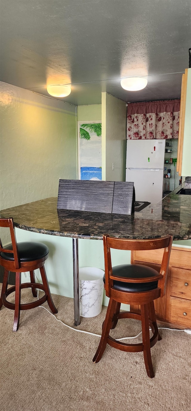 dining space featuring a textured ceiling, sink, and carpet floors