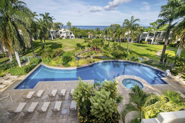 view of pool featuring a patio area, an in ground hot tub, a yard, and a water view