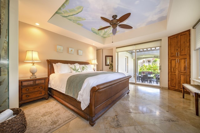 bedroom with a ceiling fan, a tray ceiling, and access to outside