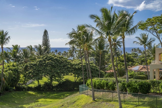 exterior space featuring a yard, a water view, and fence