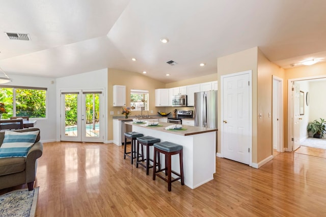 40 Hoola Lei Pl, Kihei, HI 96753 - kitchen featuring stainless steel appliances, white cabinets, a center island, plenty of natural light, and vaulted ceiling