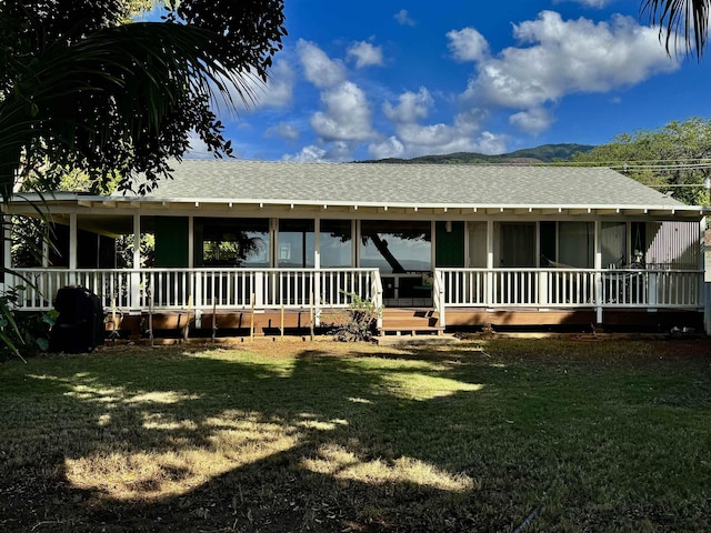 view of front facade featuring roof with shingles and a front lawn