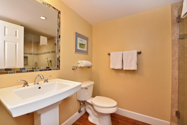 bathroom featuring sink, toilet, an enclosed shower, and hardwood / wood-style flooring