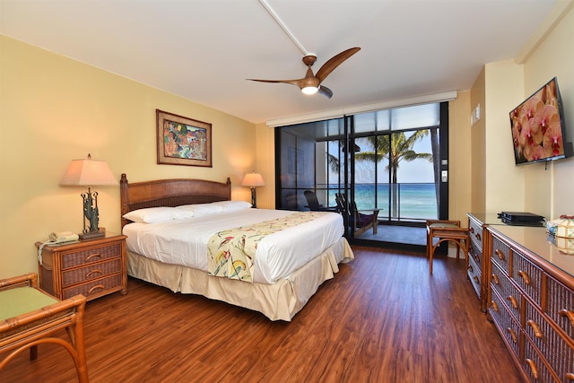 bedroom with access to exterior, dark hardwood / wood-style flooring, a wall of windows, and ceiling fan