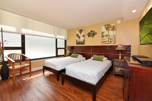 bedroom with multiple windows and dark hardwood / wood-style flooring