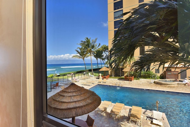 view of swimming pool with a water view and a patio