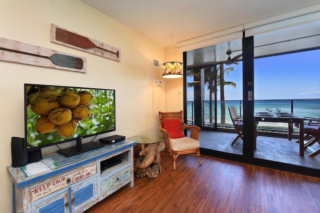 living area with hardwood / wood-style floors and a water view