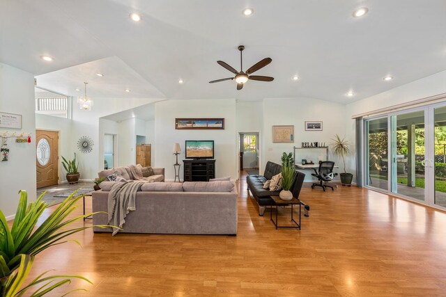 living room featuring ceiling fan, light hardwood / wood-style floors, and lofted ceiling