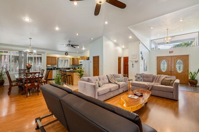 kitchen featuring white appliances, sink, vaulted ceiling, a kitchen island, and a breakfast bar area