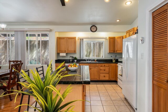 dining room featuring sink, ceiling fan with notable chandelier, light hardwood / wood-style floors, and lofted ceiling