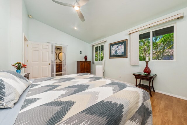 bedroom featuring light wood-type flooring, vaulted ceiling, a closet, and ceiling fan