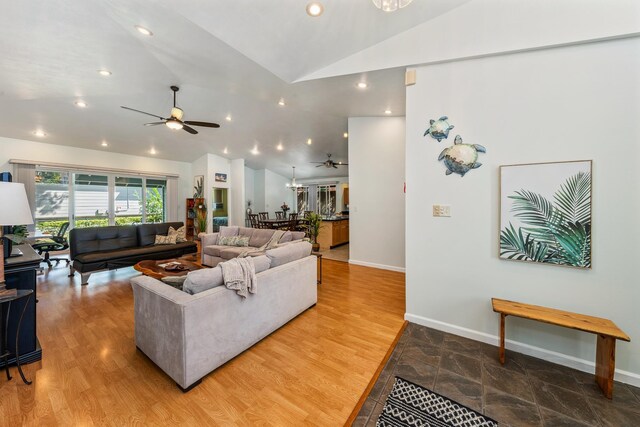 living room with ceiling fan with notable chandelier and light hardwood / wood-style flooring