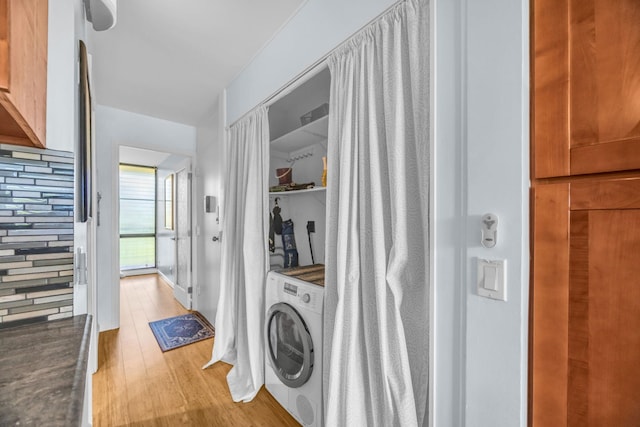laundry area featuring light wood finished floors, washer / clothes dryer, and laundry area